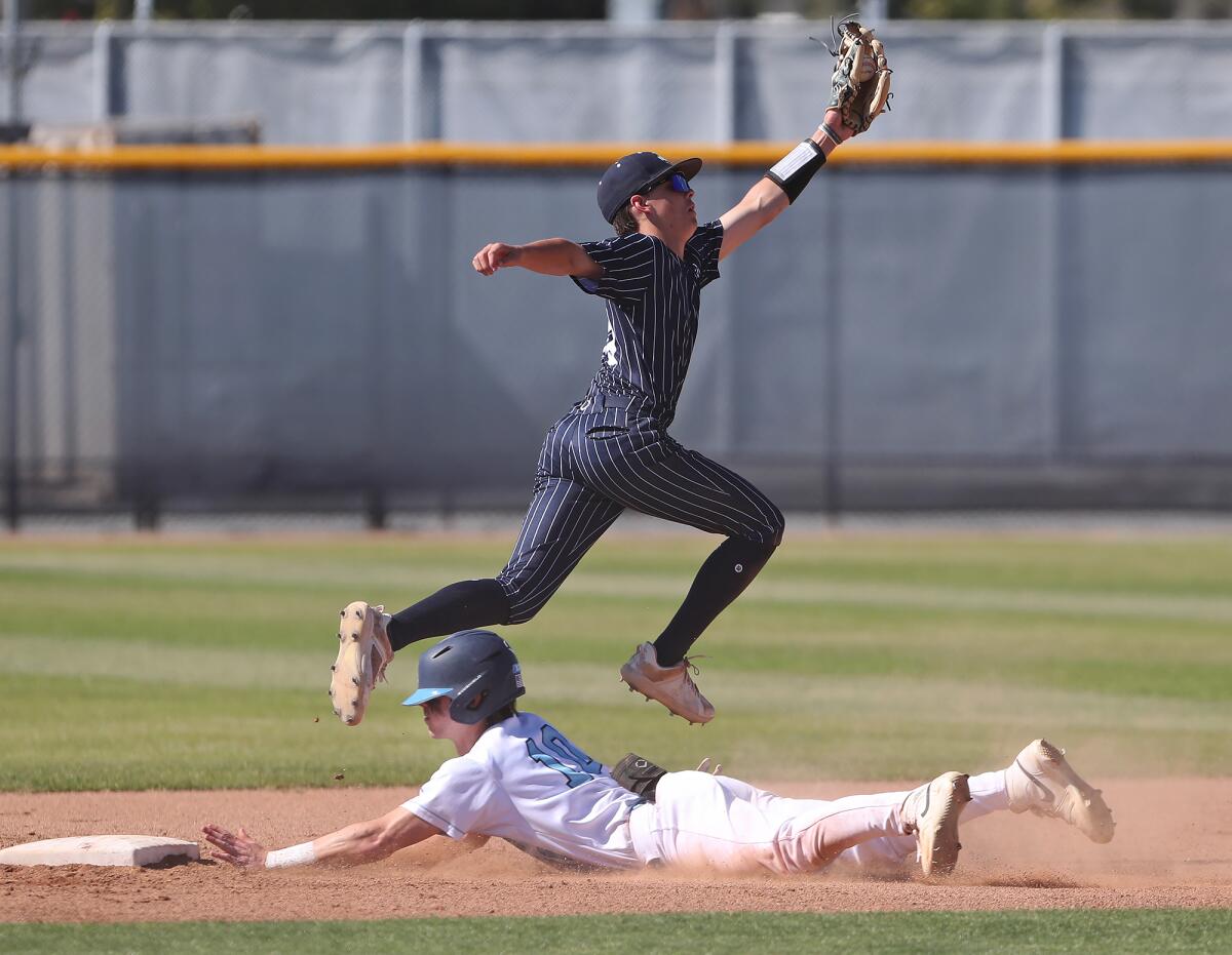 Brady Gadol (10) of Corona del Mar slides safely into second base during Wednesday's game.