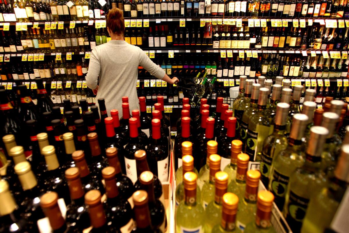 Customer Jennifer Murphy tries to decide on a bottle of wine inside the Ralph's grocery store in downtown Los Angeles