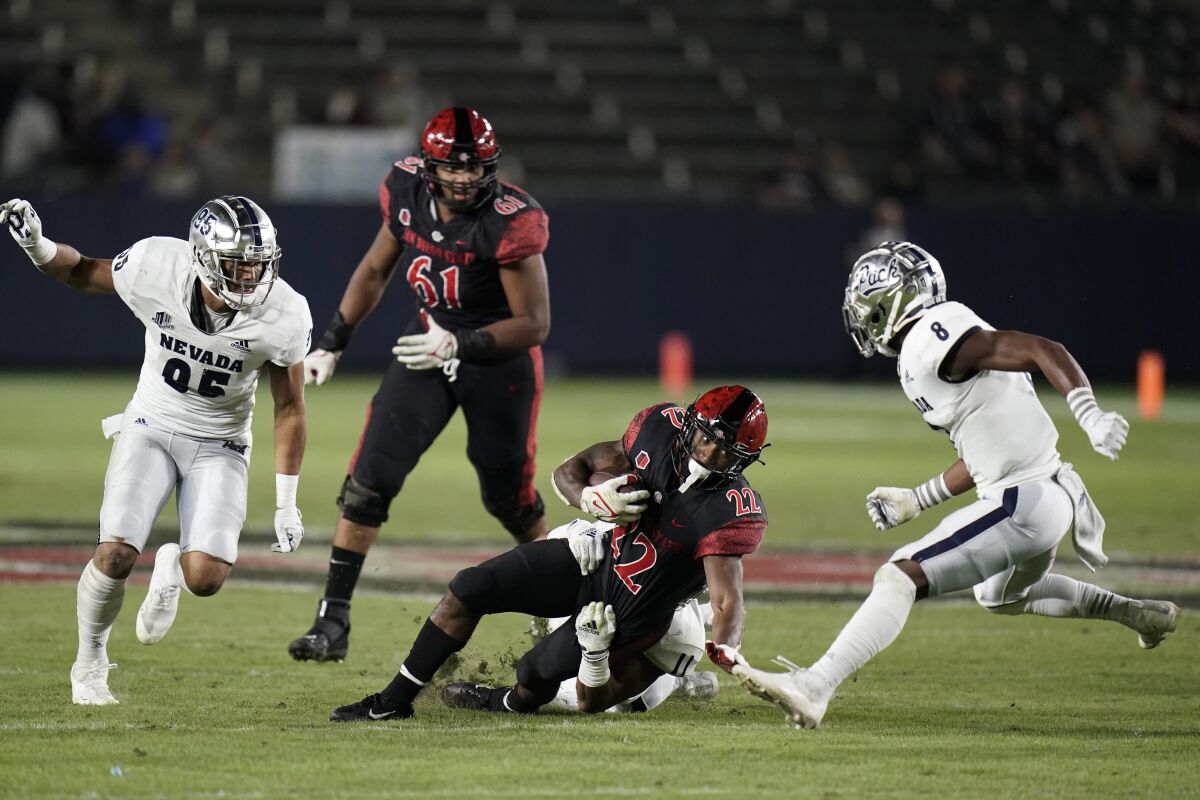 San Diego State running back Greg Bell (22) is tackled by Nevada linebacker Daiyan Henley (11) during the first half of an NCAA college football game Saturday, Nov. 13, 2021, in Carson, Calif. (AP Photo/Jae C. Hong)