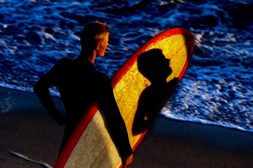 Huntington Beach If you want to learn what waves mean to surfers, go no farther than Huntington Beach, which proudly claims the title Surf City. Here, the water isn't just a recreational pastime -- it's a lifestyle. The day begins and ends with glorious sunlight and endless rides, which is why roughly 11 million visitors come each summer to watch the show. The shadow of a fellow surfer falls across another surfer's long board beneath the Huntington Beach Pier. For more in this series exploring Southern California's beaches, visit our Cruising the Coast page.