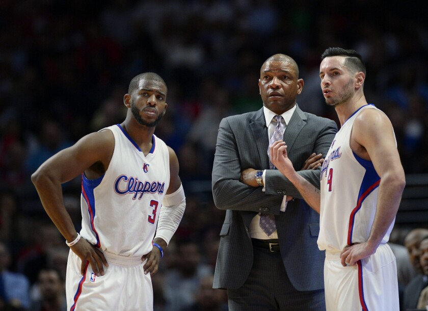 Chris Paul, left, talks with Coach Doc Rivers and J.J. Redick during a break in a game against the Houston Rockets on Feb. 11.