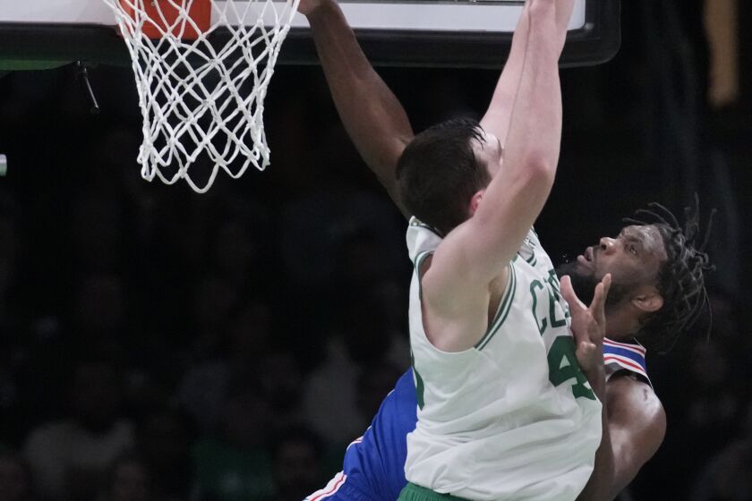 Philadelphia 76ers center Joel Embiid, rear, is blocked on a dunk attempt against Boston Celtics center Luke Kornet during the first half of an NBA basketball game, Wednesday, Feb. 8, 2023, in Boston. (AP Photo/Charles Krupa)
