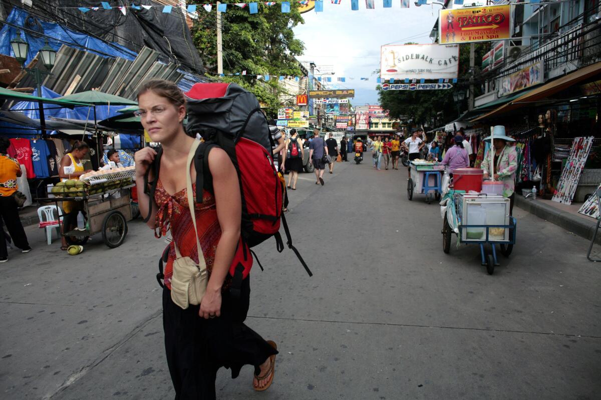A backpacker walks down Khaosan Road, a favorite tourist destination.