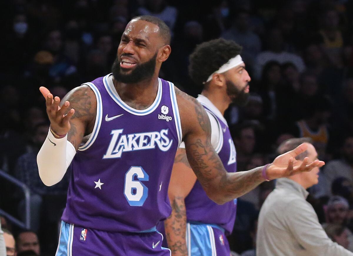 Lakers forward LeBron James holds his hands out to react to a foul call.