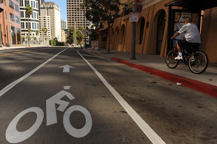 A byclist rides on the sidewalk despite the new commuter bike lane on 7th Street in downtown Los Angeles.