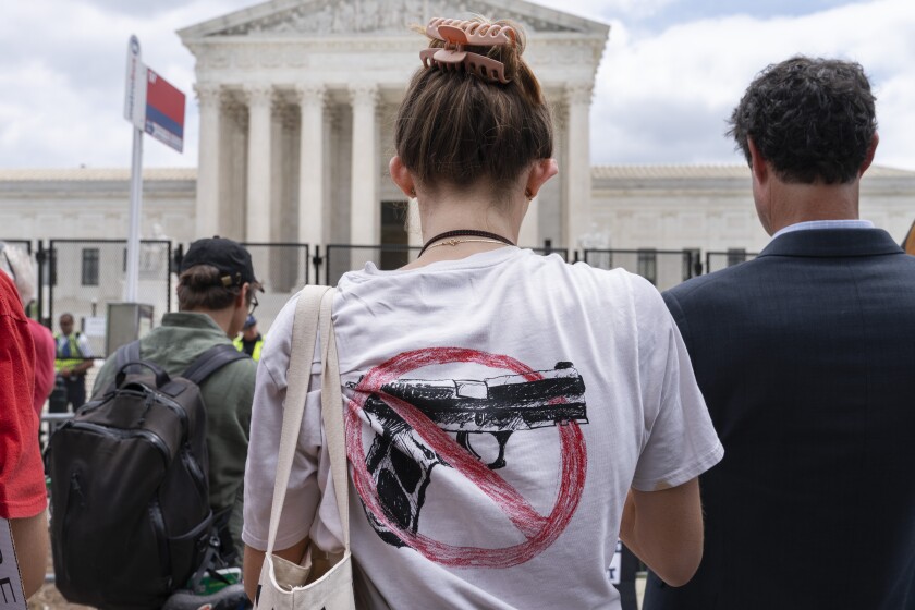 A woman wears an anti-gun T-shirt outside of the Supreme Court, following the Supreme Court's decision to overturn Roe v. Wade in Washington, Friday, June 24, 2022. The Supreme Court on Thursday struck down a New York state law that had restricted who could obtain a permit to carry a gun in public.(AP Photo/Jacquelyn Martin)