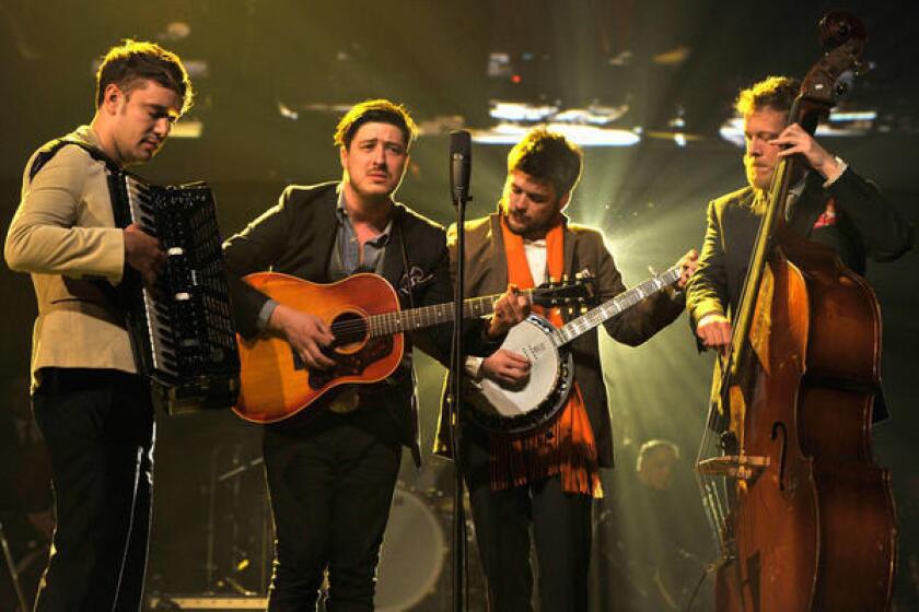 Mumford & Sons at the Grammys in 2013. The band canceled three dates on its current tour after bassist Ted Dwayne, right, was hospitalized with a blood clot.