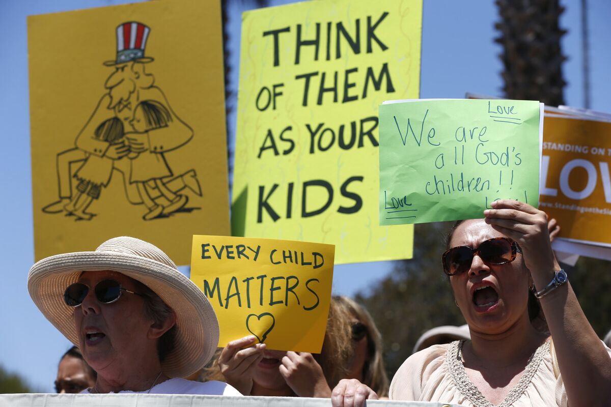 Karla Salazar, right, and Ellen Leonard on Tuesday joined nearly 100 demonstrators at the naval base in Port Hueneme, where hundreds of immigrant children are being housed.