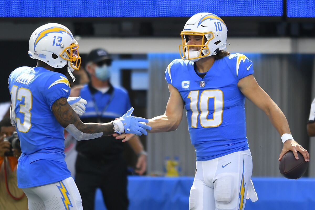 Justin Herbert (10) of the Los Angeles Chargers celebrates with Keenan Allen after running for a touchdown.