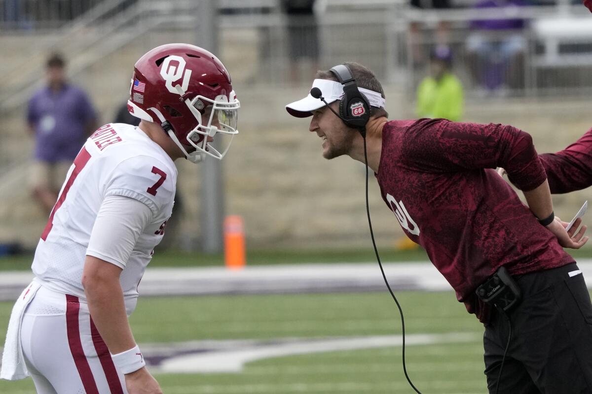 Oklahoma coach Lincoln Riley, right, talks with quarterback Spencer Rattler during a game against Kansas State