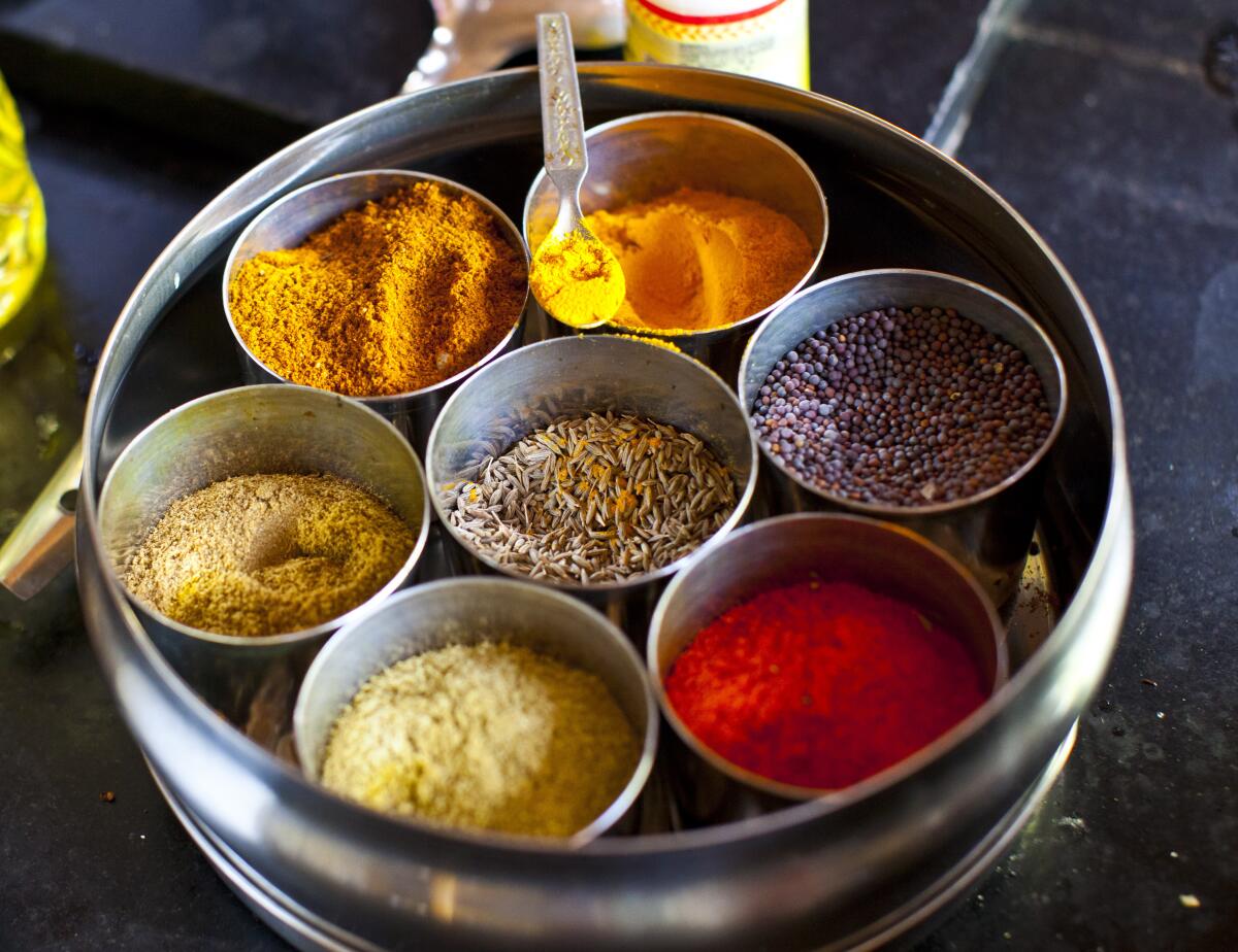 Indian spices are displayed on a tray. 