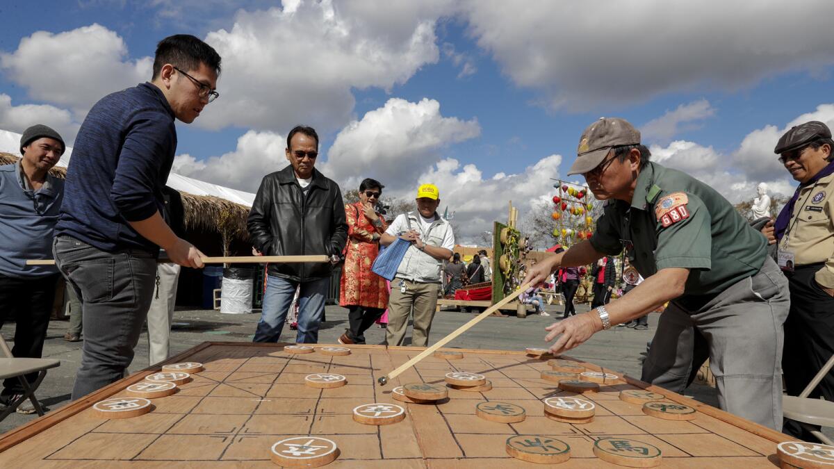 Daniel Le, 27, left, and Doan Nguyen, 69, play Chinese chess at the Tet Festival.