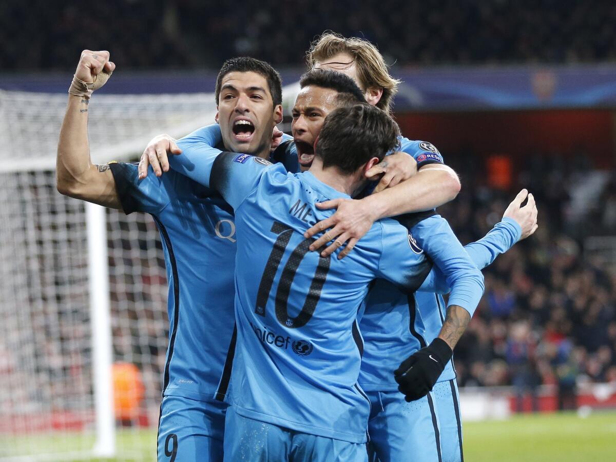 Barcelona players celebrate after Lionel Messi scored the opening goal during the soccer Champions League round of 16 first leg soccer match between Arsenal and Barcelona at the Emirates stadium in London, Tuesday, Feb. 23, 2016. (AP Photo/Frank Augstein)