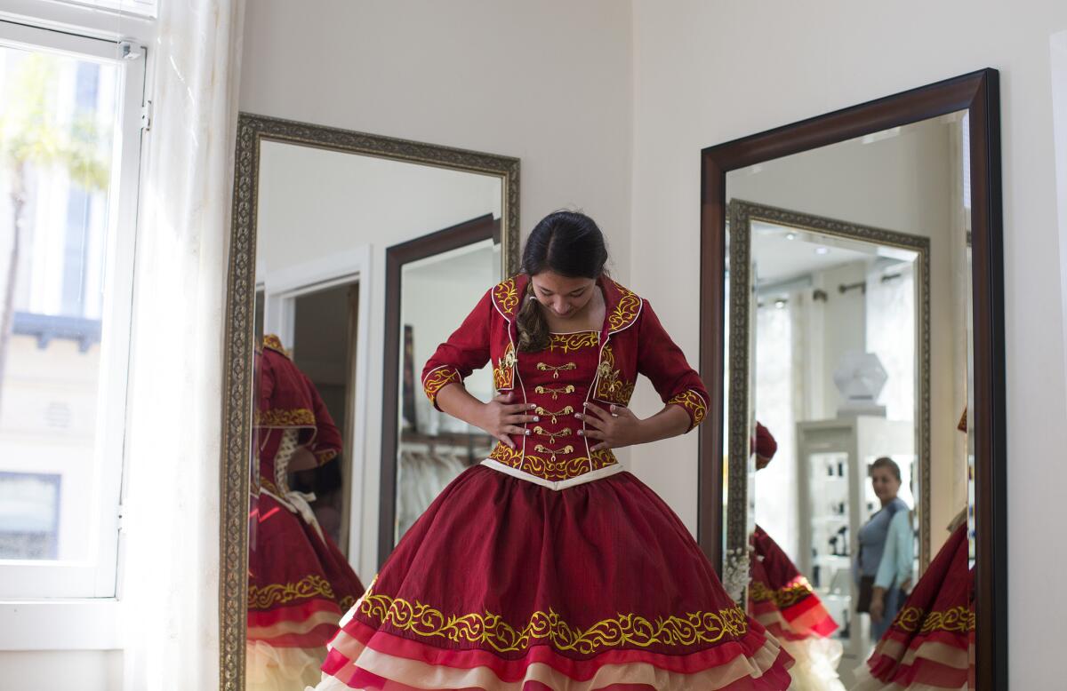 Audrey Arellano, 14, of Irvine admires the details of a Mariachi style quinceañera dress at Genesis Bridal Boutique.