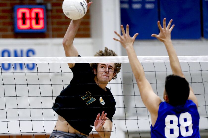 Edison's Emerson Evans (11) goes high to make a kill during Wave League boys' volleyball match against Fountain Valley on Friday.