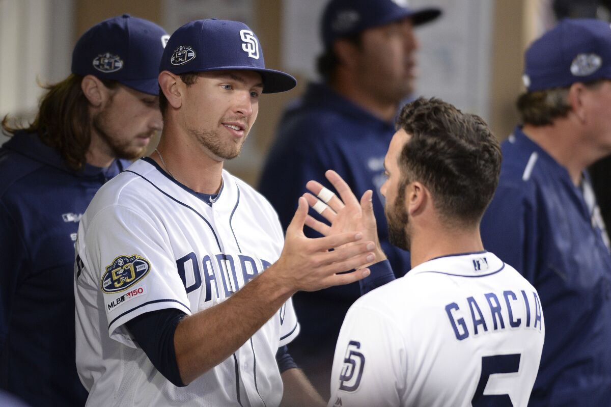 Padres rookie Nick Margevicius is greeted by Greg Garcia in the dugout after being removed in the sixth inning of his major league debut on March 30.
