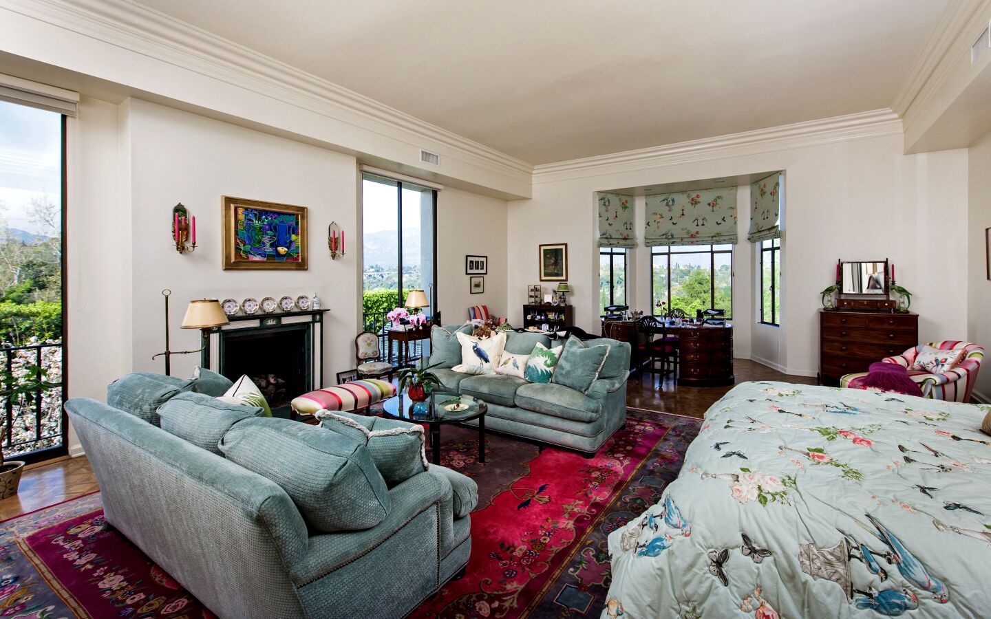 A bedroom inside the ornate home with windows providing views of Pasadena