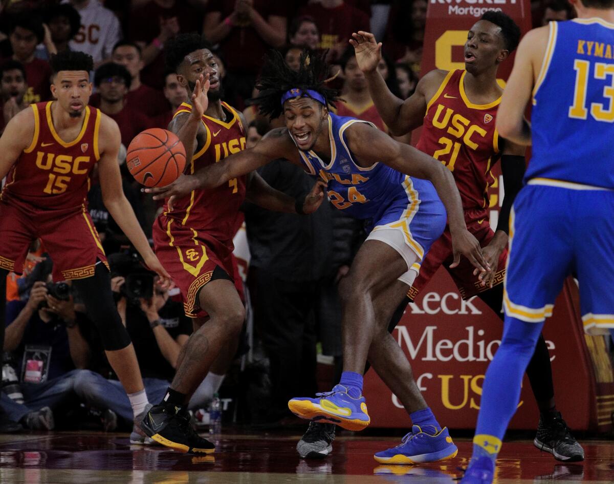 UCLA forward Jalen Hill (24) loses the ball as he's triple teamed by USC's Isaiah Mobley (15), Daniel Utomi (4), and Onyeka Okongwu (21) during the second half of a game March 7, 2020, at Galen Center.