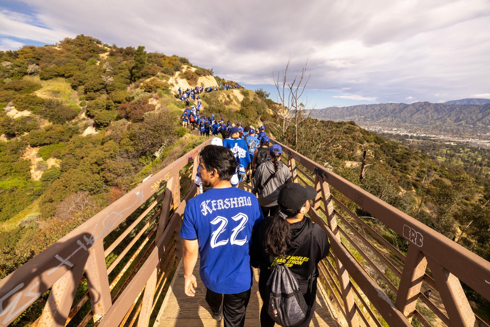 Throngs of hikers from the Dodgers Blue Hiking Crew cross a bridge on the way to Mt. Hollywood.