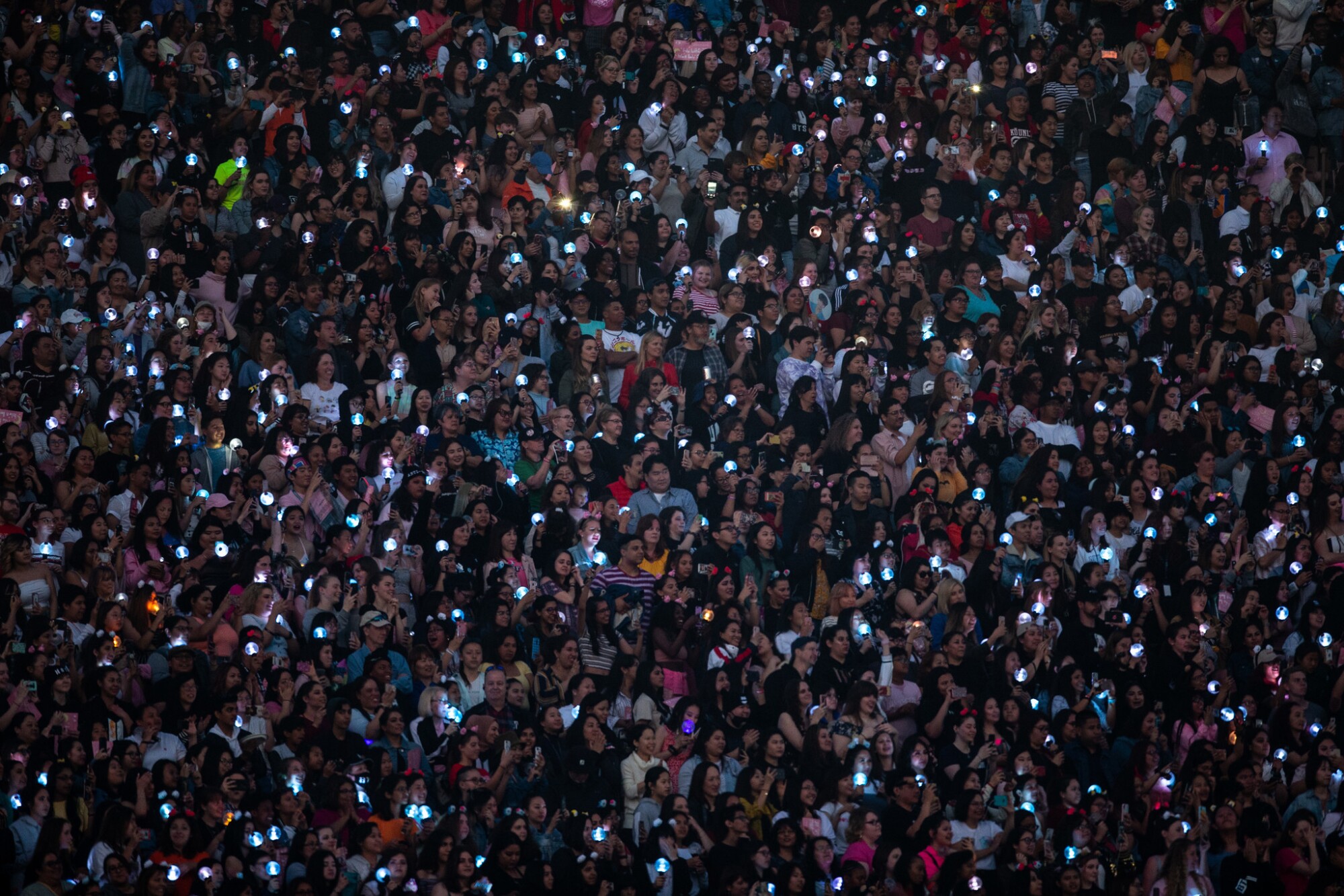 A mass of people holding up lighted phones.
