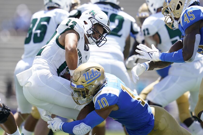 Hawaii Warriors quarterback Chevan Cordeiro (12) is sacked by UCLA Bruins linebacker Ale Kaho (10) during the first half of an NCAA college football game Saturday, Aug. 28, 2021, in Pasadena, Calif. (AP Photo/Ashley Landis)