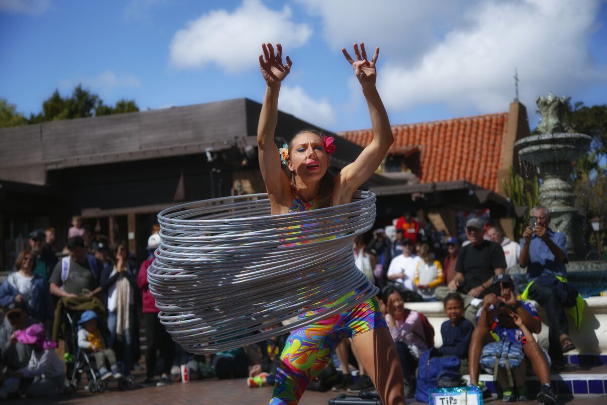 Hillary Matson from Canyon Lake uses 30 hula-hoops to create her giant slinky during a her performance for the crowd attending Seaport Village's Spring Busker Festival in 2017.