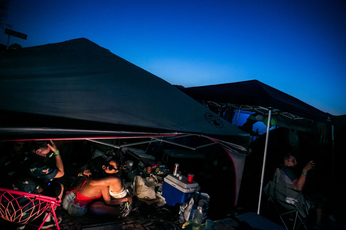 Campers hug at their tent at night.