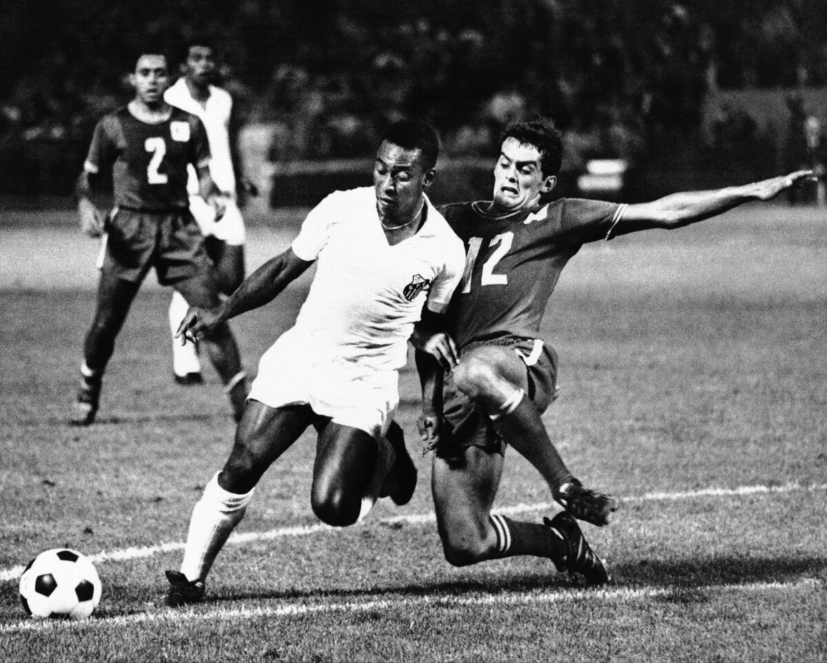 Pelé, left, controls the ball during an exhibition match between Santos and the Oakland Clippers.