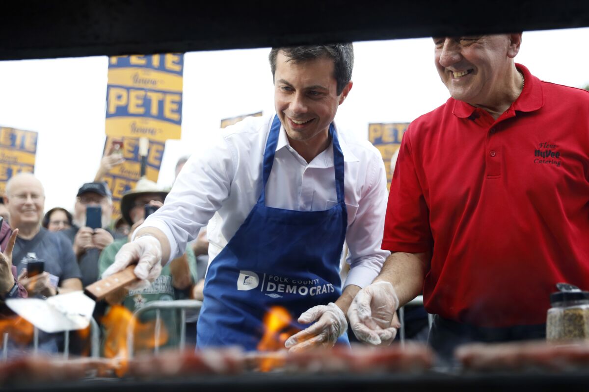 Democratic presidential candidate Pete Buttigieg works the grill during the Polk County Steak Fry in Des Moines.