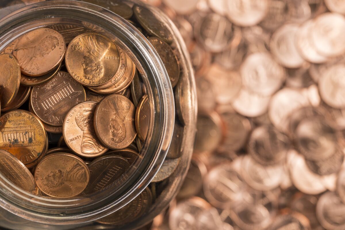 A jar of pennies surrounded by pennies.