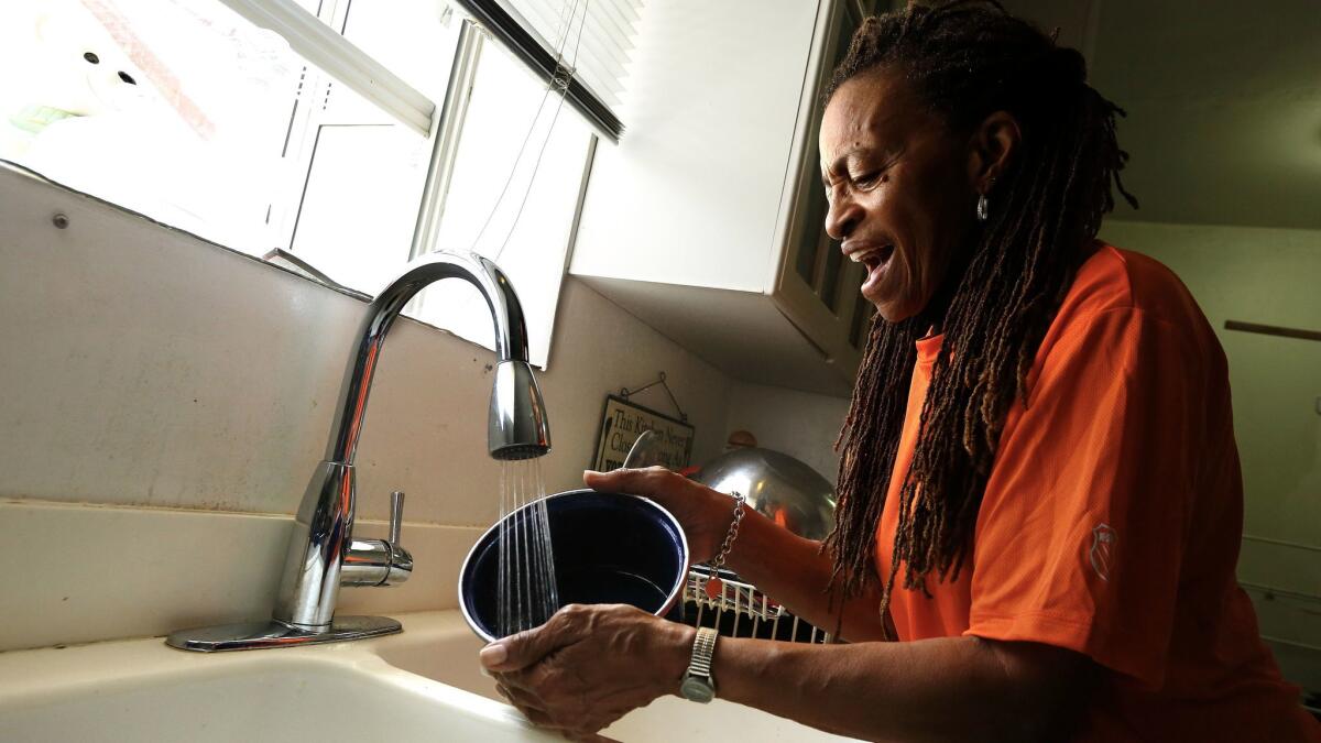 Doris Tillman, 71, washes pots and pans with running water — a luxury she was without for nine months after falling behind on an LADWP bill she disputed. She was able to make the required payment on the bill thanks to donations from readers who learned of her situation.
