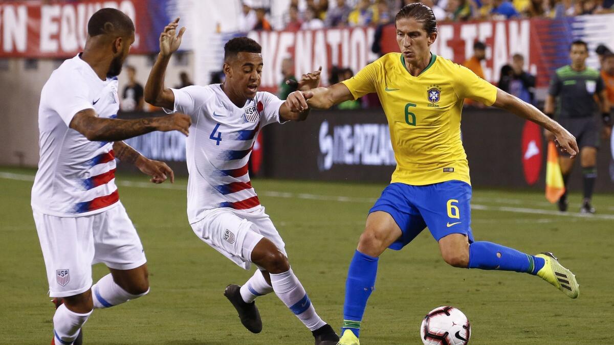 DeAndre Yedlin and Tyler Adams defend Filipe Luís of Brazil during their friendly match at MetLife Stadium on September 7.