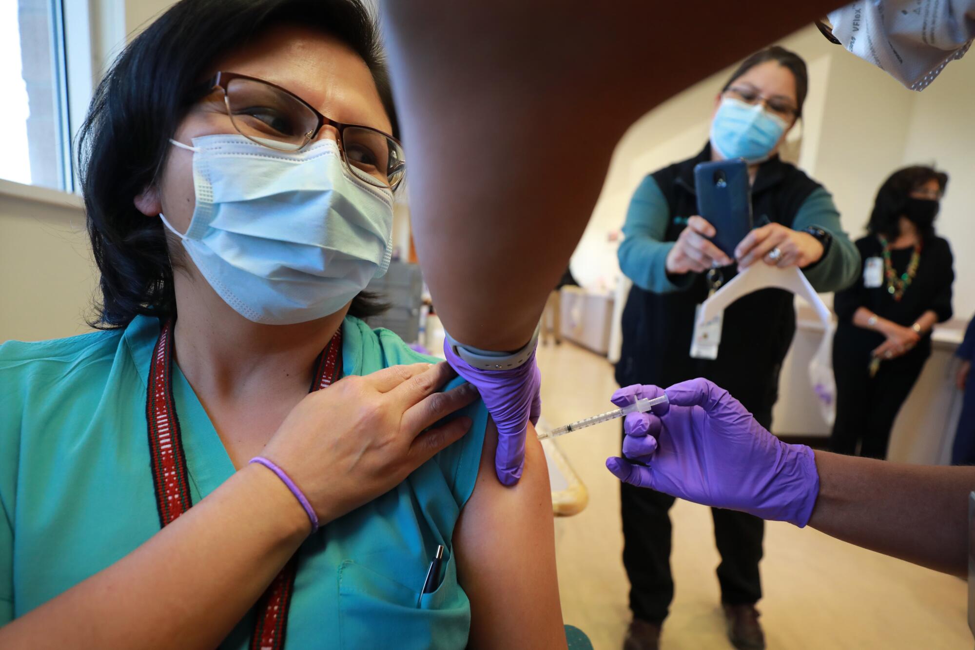 Dr. Lawanda Jim receives a COVID-19 vaccine Tuesday at the Northern Navajo Medical Center in Shiprock, N.M.