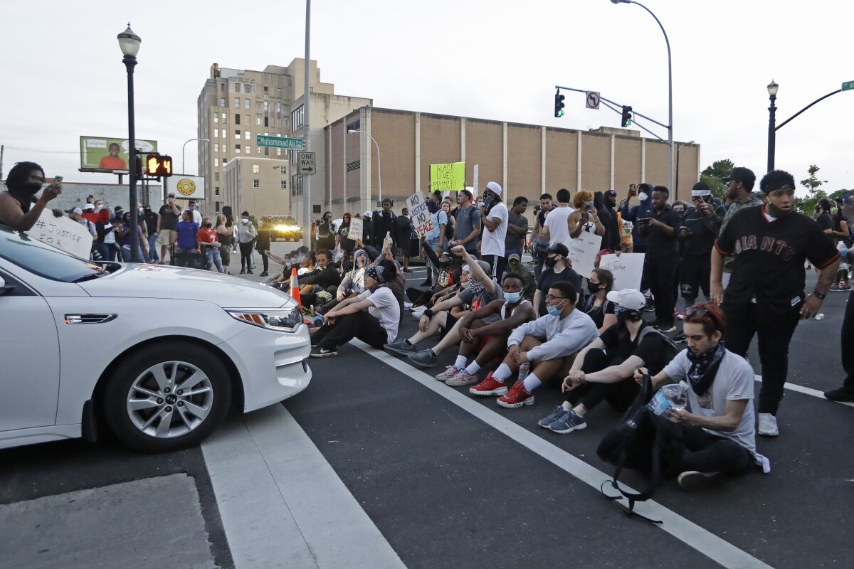 Protesters sit at an intersection during a protest over the deaths of George Floyd and Breonna Taylor on May 30, 2020, in Louisville, Ky.