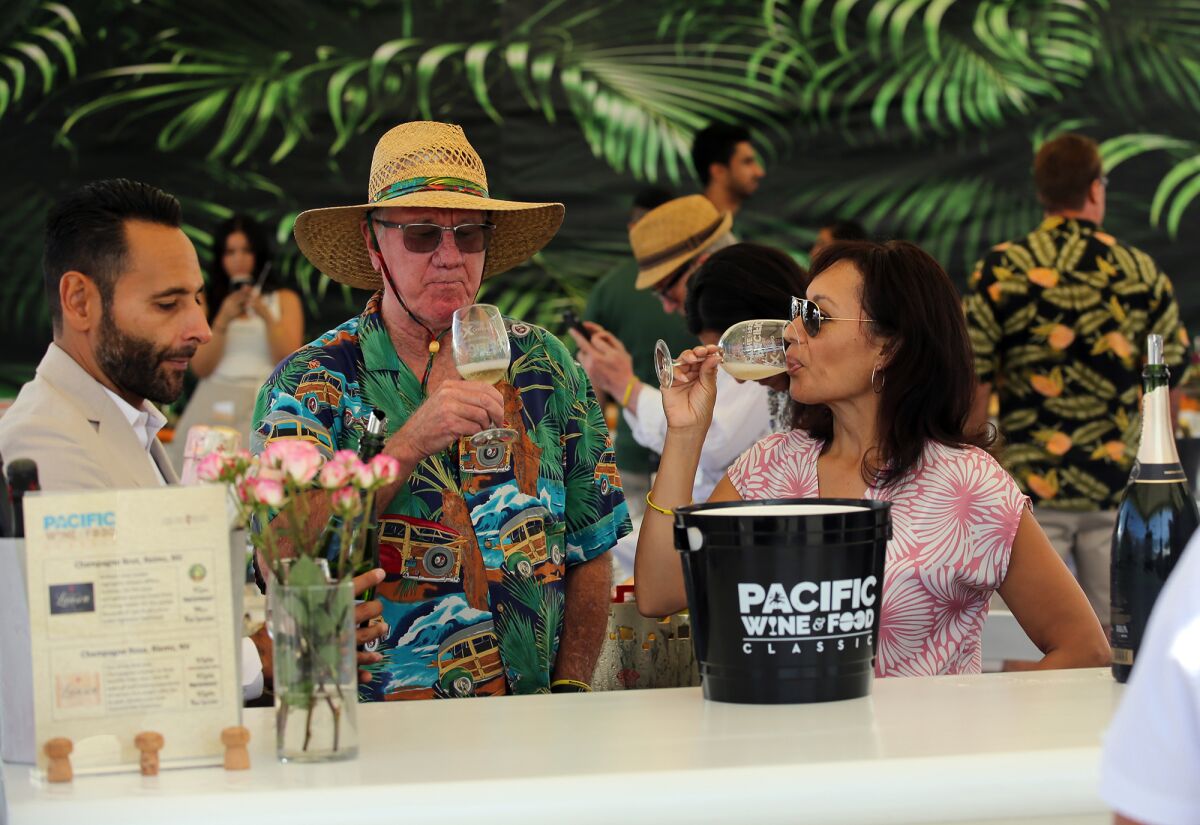 Guests taste Lanson Champagne during the Pacific Wine & Food Classic at the Newport Dunes in Newport Beach on Saturday.