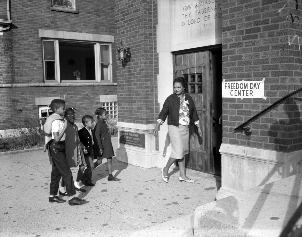 Luberda Bailey, head of the 71st and Sangamon Block Club, leads children from Guggenheim Elementary School to the Freedom School held in the basement at New Friendship Baptist Church on Oct. 22, 1963. The students boycotted their regular school as a protest against segregated schools in Chicago.