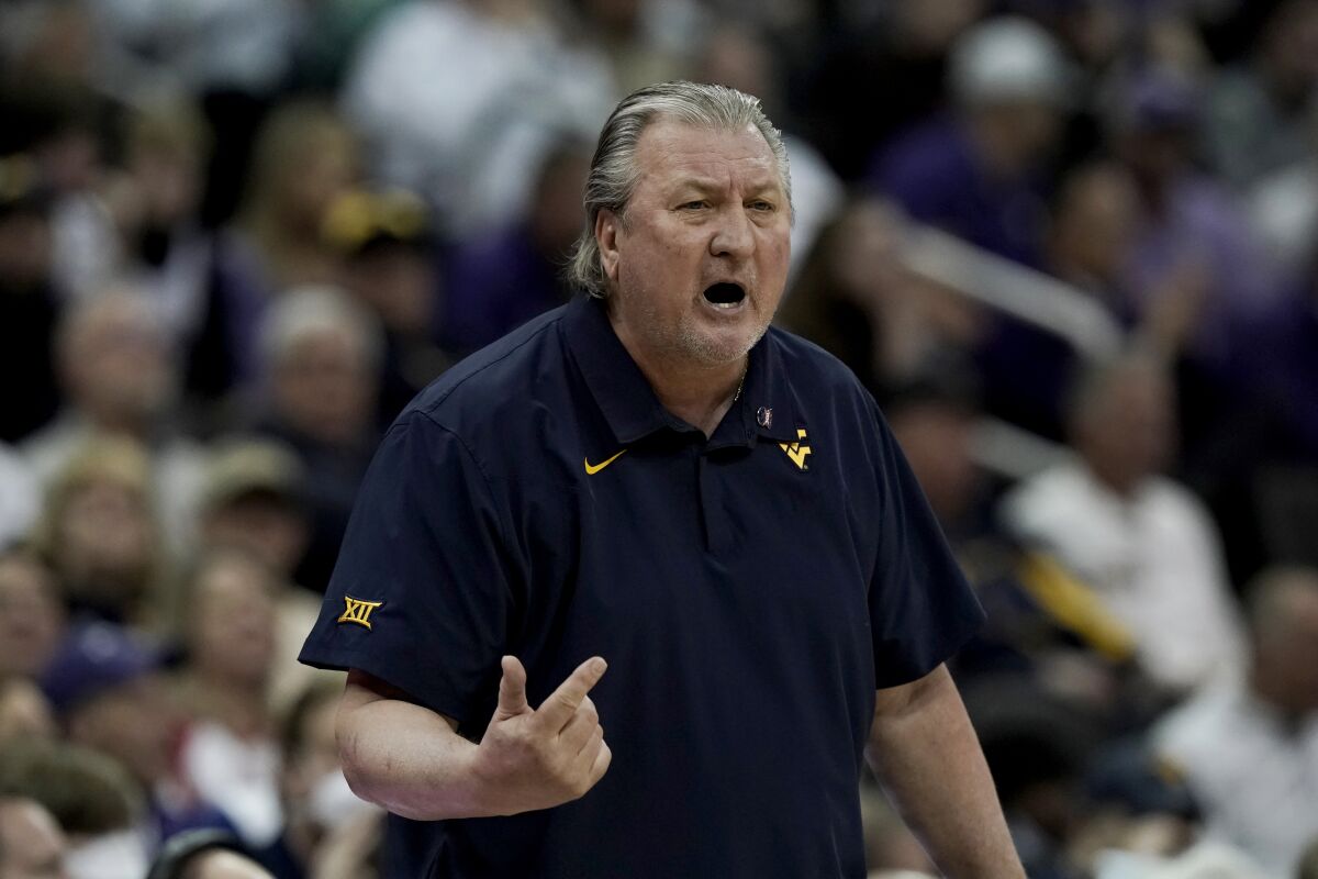 West Virginia coach Bob Huggins talks to players during the first half of the team's NCAA college basketball game against Kansas State in the first round of the Big 12 Conference tournament in Kansas City, Mo., Wednesday, March 9, 2022. (AP Photo/Charlie Riedel)
