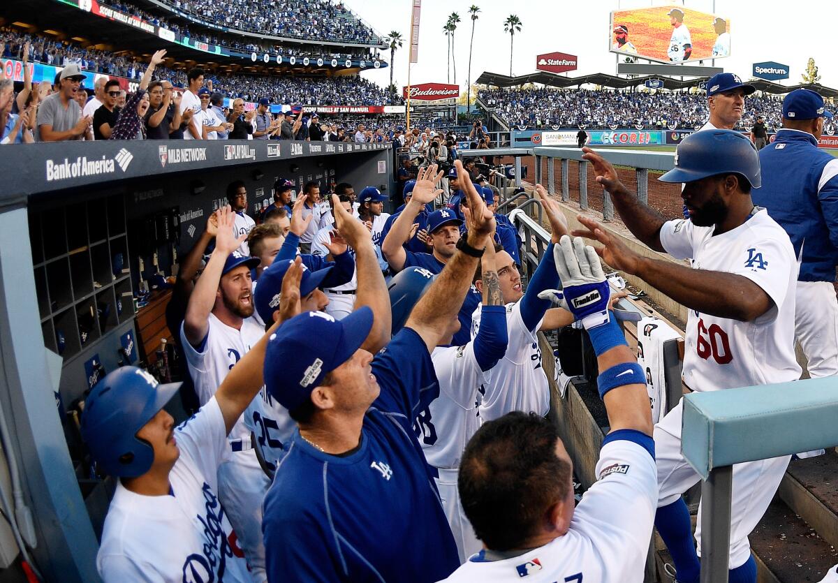 Dodgers' Andrew Toles celebrates with teammates after scoring on a single by Chase Utley.