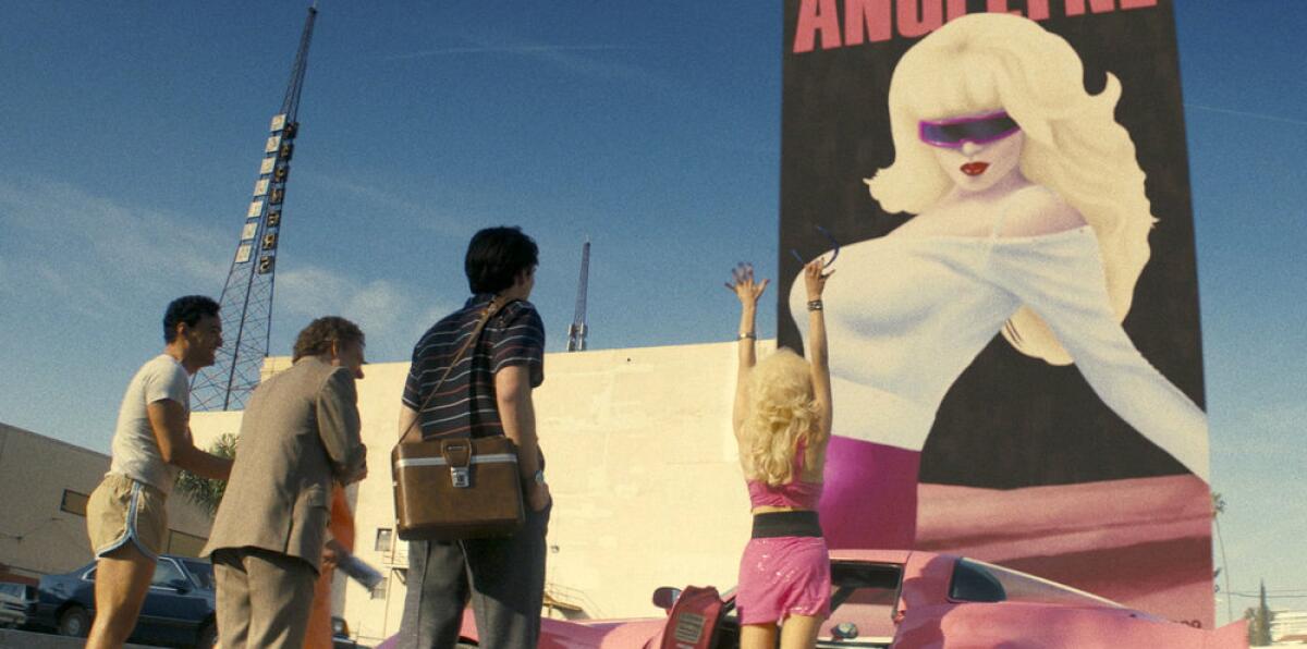 A woman and her entourage look on a massive mural of her.