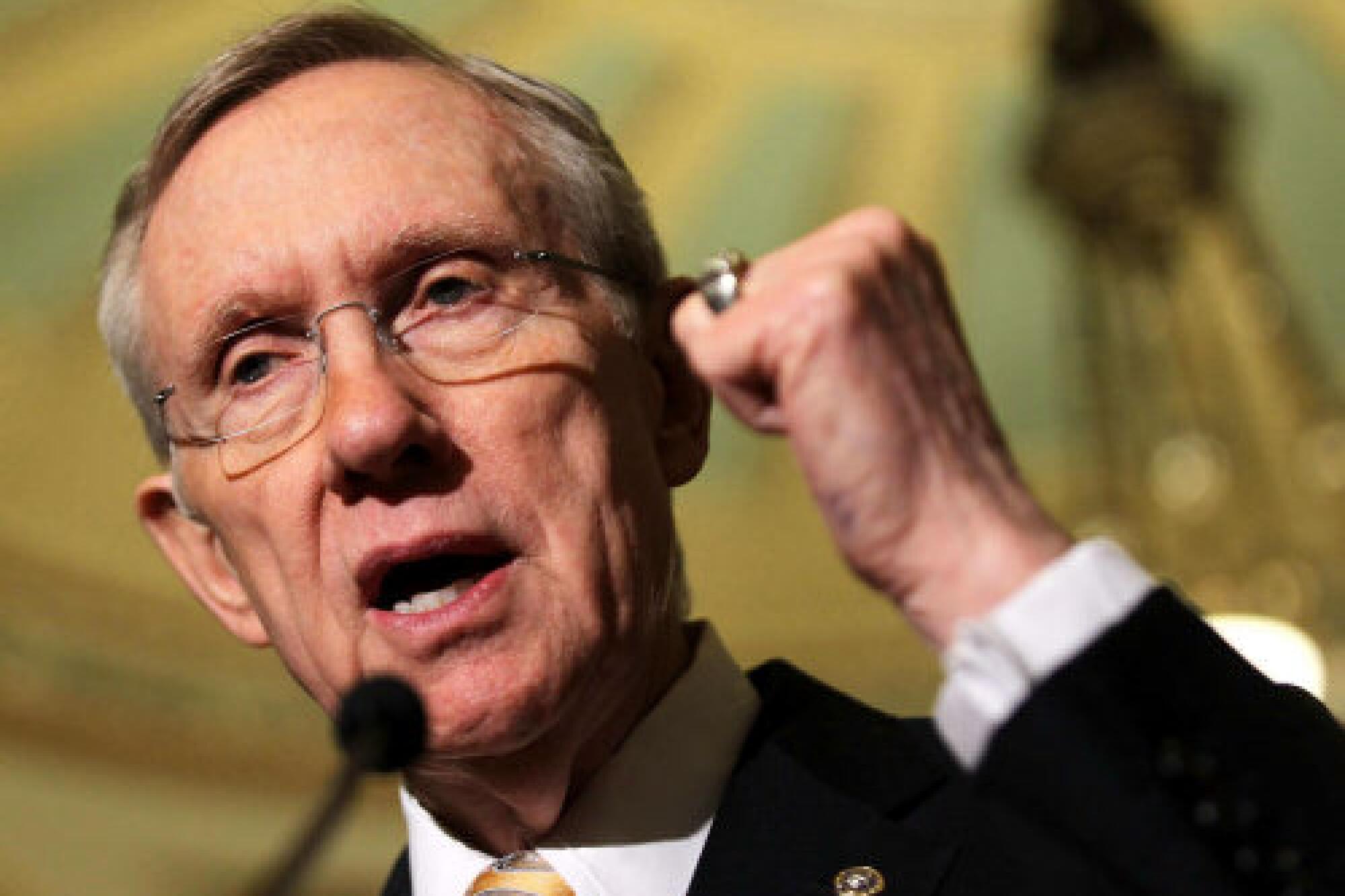 A closeup of then-Senate Majority Leader Harry Reid clenching his left fist as he speaks into a microphone