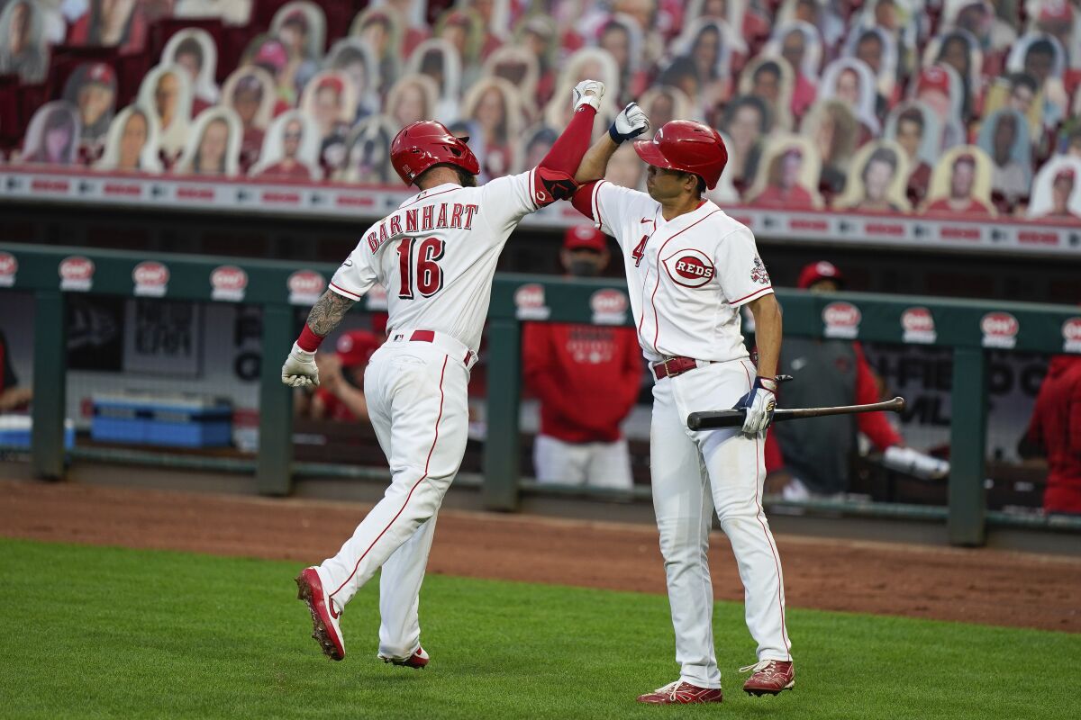 Cincinnati Reds' Tucker Barnhart (16) celebrates with Shogo Akiyama (4) after hitting a home run during the second inning of the team's baseball game against the Pittsburgh Pirates in Cincinnati, Tuesday, Sept. 15, 2020. (AP Photo/Bryan Woolston)
