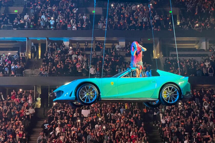 Karol G abordo de su Ferrari en lo lato del Honda Center de Anaheim durante su llegada a la ciudad como parte de su gira "$trip Love Tour".
