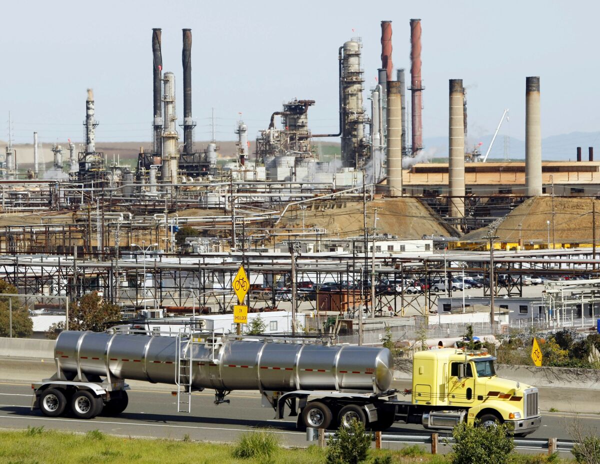 A tanker truck passes the Chevron oil refinery in Richmond, Calif., in 2010.