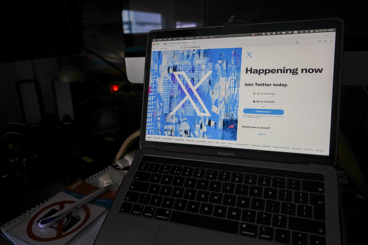 A view of a laptop shows the Twitter sign-in page with the new logo