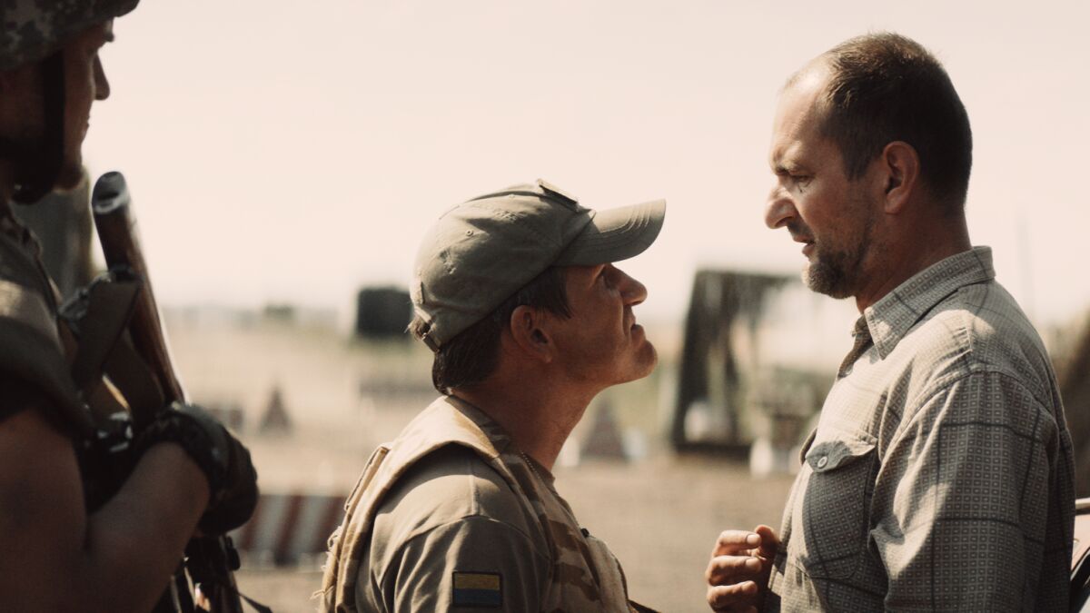 Two soldiers question a civilian in the movie "Bad Roads."