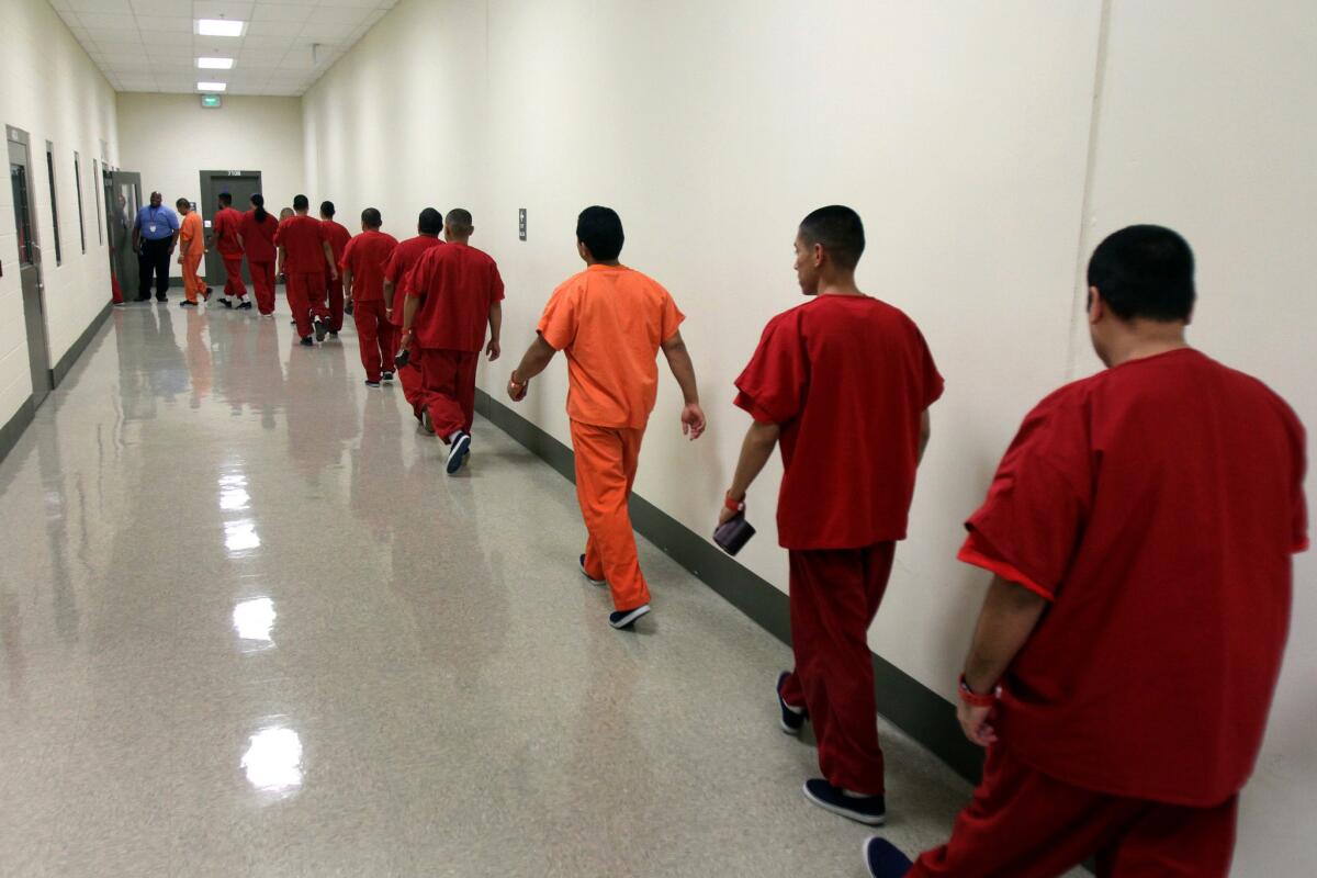Detainees walk down a hallway at an immigrant detention center in Adelanto in 2013.