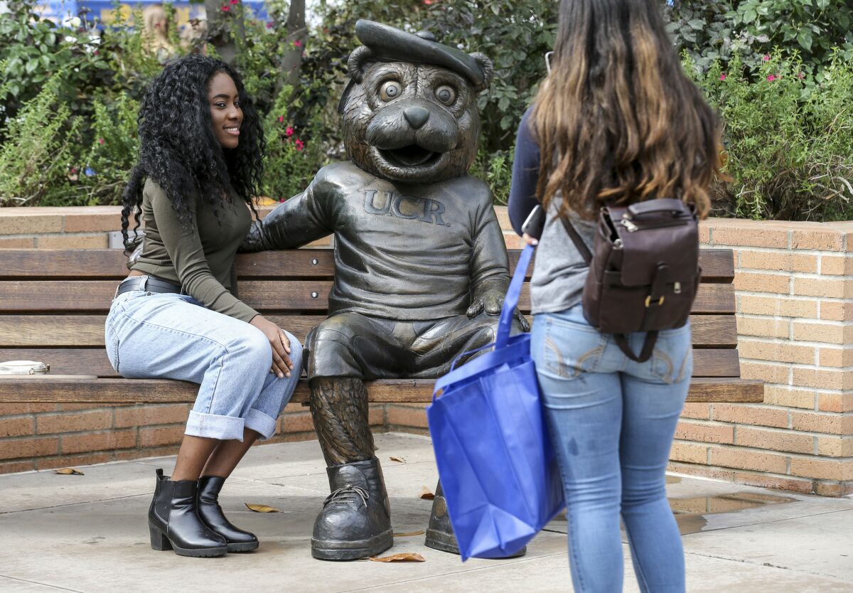 Tiffany Isichei, 18, left, gets her photo taken with "Scotty" at UC Riverside on Highlander Day.