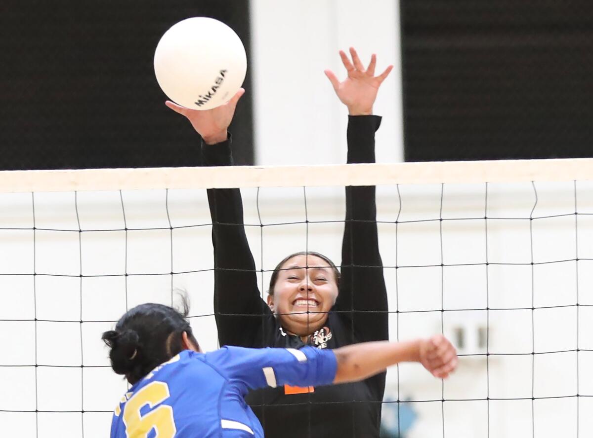 Los Amigos middle blocker Aileen Nunez (2) blocks a shot by Channel Islands' Bea Cerezo on Tuesday.