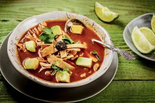 A bowl of sopa Azteca, a pasilla chile and tomato broth-based soup.