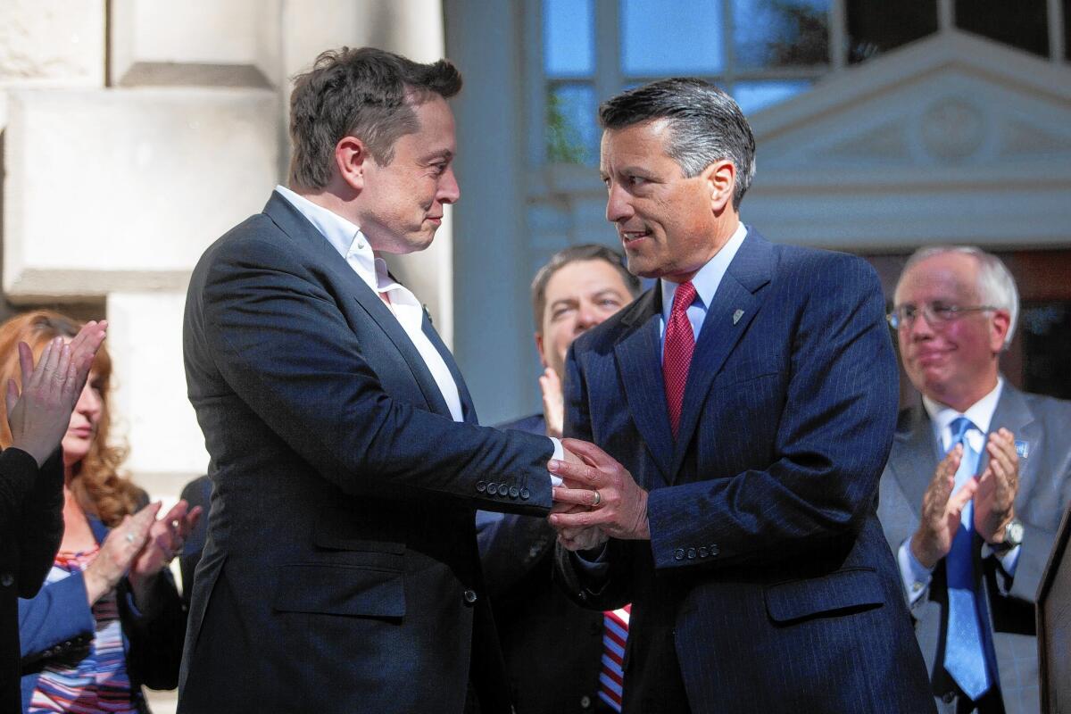 Elon Musk, left, CEO of Tesla Motors, at a Capitol news conference with Nevada Gov. Brian Sandoval.